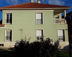 托爾德西拉斯的住宿－El olivo，绿色房子,设有窗户和红色屋顶