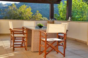 Duas cadeiras e uma mesa num pátio com vista em Lola's Cottage & Garden em Kalokhorio