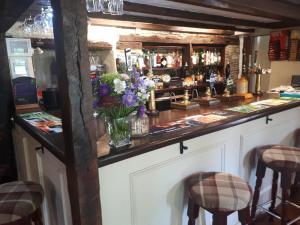 un bar con un mostrador con un jarrón de flores en Seven Stars Inn en Builth Wells