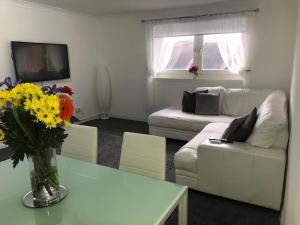a living room with a couch and a table with flowers at Modern 2 bed Apartment Near City Centre in Glasgow
