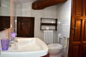 a white bathroom with a toilet and a sink at Locanda Giolica in Prato