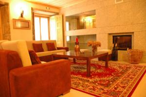 un soggiorno con tavolino e camino di Casa Avó Alice a Seia