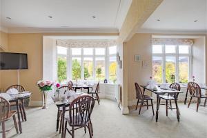 a dining room with tables and chairs and a large window at Brantholme Bed & Breakfast in Ambleside