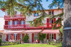 Edificio rojo y blanco con balcón en Aita Baita, en Ciboure