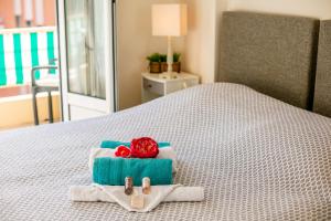 Una cama con dos toallas y una rosa. en VILLA DUBOUCHAGE AP2066 - Nice, by Riviera Holiday Homes, en Niza