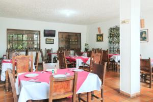 a dining room with red and white tables and chairs at Hotel Colonial Plaza in Bucaramanga