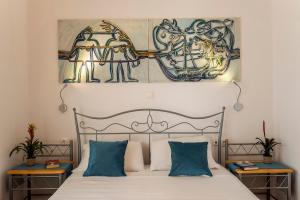 1 dormitorio con 1 cama con una pintura en la pared en Villa Giannis, en Almyrida