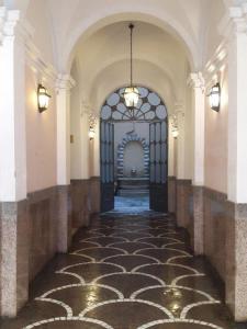 un couloir vide avec une grande porte dans un bâtiment dans l'établissement La Residenza Suites, à Rome