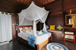 1 dormitorio con 1 cama con dosel en Poh Manis Lembongan, en Nusa Lembongan