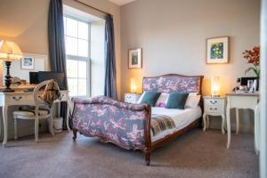 una camera da letto con un letto, una scrivania e una sedia di Emmet Hotel a Clonakilty