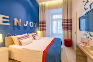 a bedroom with a bed, a dresser, and a window at Estilo Fashion Hotel Budapest in Budapest