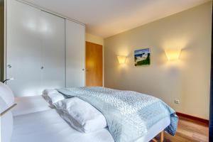- une chambre avec un lit blanc et deux lumières sur le mur dans l'établissement Schloonseevillen SV_25, à Bansin