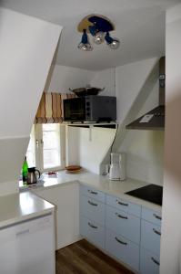 a small kitchen with white cabinets and a staircase at Ohl Dörp 10, Wrixum auf der Insel Föhr in Wrixum