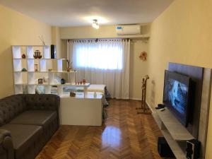 uma sala de estar com um sofá e uma televisão de ecrã plano em Palermo Soho, Un Lugar Soñado en Plaza Serrano em Buenos Aires