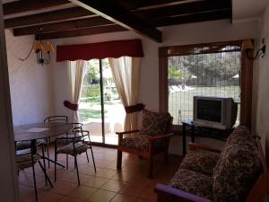 un soggiorno con TV, tavolo e sedie di Stellamar Apart Hotel a La Serena