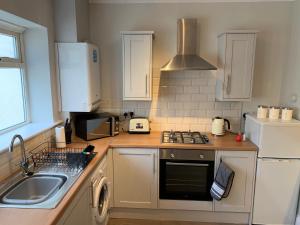 a kitchen with a sink and a stove top oven at Durham 3 Bedroom House With Parking in Durham