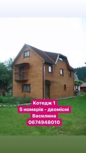 ein Haus mit einem Schild davor in der Unterkunft Pidkova in Werchowyna