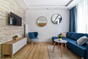 a living room with a blue couch and a brick wall at Old Town LTC - Apartments Starówka Szeroka in Gdańsk