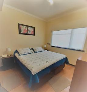um quarto com uma cama com duas almofadas e uma janela em Hotel Vista Hermosa 17 em Viña del Mar