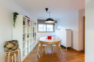 a kitchen and dining room with a table and chairs at Deluxe Modern Flat with Balcony by Host Wise in Porto