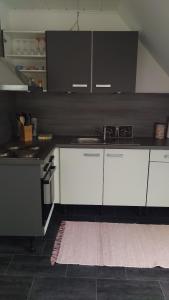 uma cozinha com armários brancos e um balcão preto em Ferienwohnung Fusi em Amberg