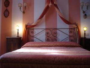 1 dormitorio con 1 cama con dosel y 2 lámparas en Casale La Fornace, en Costacciaro