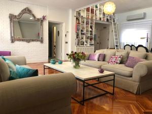 una sala de estar con sofás y una mesa con flores en chalet villa inside Madrid, en Madrid