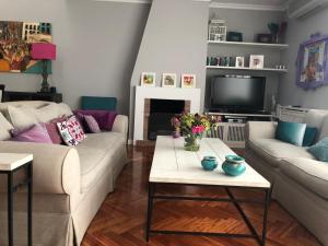 sala de estar con 2 sofás y TV en chalet villa inside Madrid, en Madrid