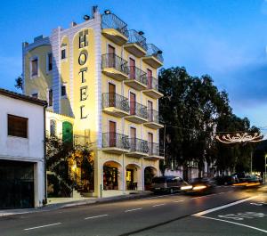 a building with a hotel on the side of a street at Hotel Villarosa con Vespa Rent in Sarroch