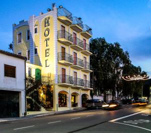 un edificio con un hotel al lado de una calle en Hotel Villarosa con Vespa Rent, en Sarroch