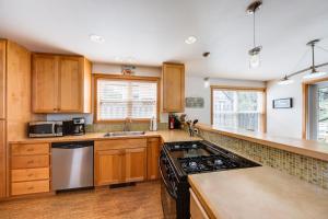 a kitchen with wooden cabinets and a stove top oven at Beachcomber's Paradise in Pacific City