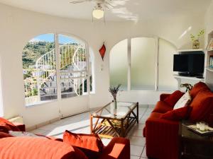 a living room with a red couch and a ferris wheel at Apartment at Casa Piña Blanca in Benissa