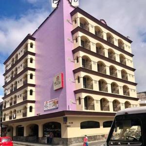 un edificio rosa con un reloj al costado. en Hotel Bello Cordoba en Córdoba