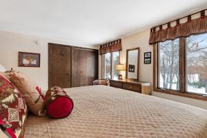 a bedroom with a large bed and two windows at Cleerwood Village #252 in Eagle River