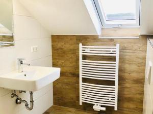 baño con lavabo blanco y ventana en Gästezimmer am Hochrhein, en Lauchringen