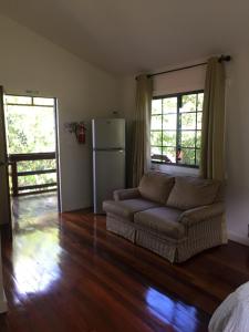 a living room with a couch and a refrigerator at Santa Cruz Cabins in Santa Elena