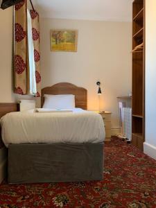 A bed or beds in a room at Twickenham Guest House 