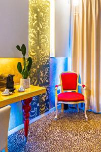 a room with a red chair and a table at Antony Palace Hotel - Venice Airport in Marcon