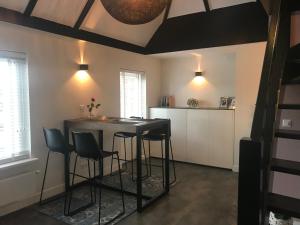 a kitchen with a table and chairs in a room at Pakhuis 5 in Katwijk aan Zee