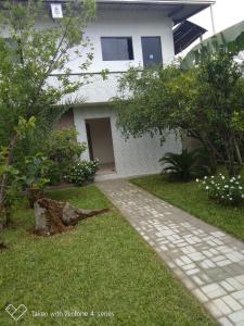 a walkway in front of a white house at Hospedagem Navegantes in Navegantes