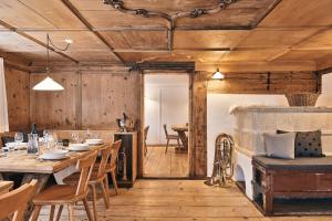comedor con mesa, sillas y paredes de madera en Wald 12 Ferienhaus, en Wald am Arlberg