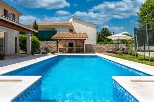 a swimming pool with a gazebo next to a house at Villa Natasha - charming Istrian villa with private heated pool in Ružići