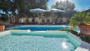 einen Pool mit Stühlen und Sonnenschirmen im Hof in der Unterkunft Laniella location in Calvi