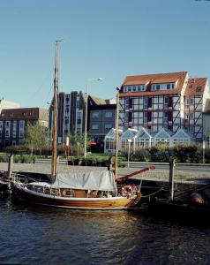 un barco está atracado en el agua junto a los edificios en Hotel & Restaurant Alter Speicher, en Greifswald