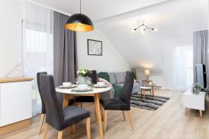 a dining room and living room with a table and chairs at Apartments Gdańsk Kochanowskiego by Renters in Gdańsk