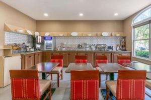 a restaurant with tables and chairs and a kitchen at Comfort Inn & Suites Nashville Franklin Cool Springs in Franklin