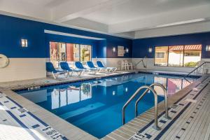 新倫敦的住宿－新倫敦/米斯蒂克拉麗奧酒店，一座拥有蓝色墙壁和蓝色椅子的酒店游泳池
