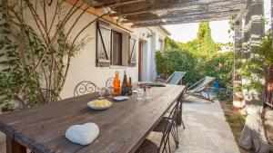 - une table en bois avec un bol de nourriture sur la terrasse dans l'établissement Laniella location, à Calvi