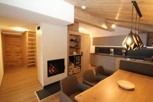 a kitchen and dining room with a table and a fireplace at Schösserhof in Zell am Ziller
