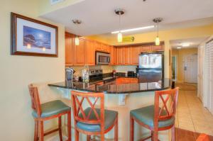 a kitchen with a island with chairs and a counter top at Horizon at 77th Avenue North by Palmetto Vacations in Myrtle Beach